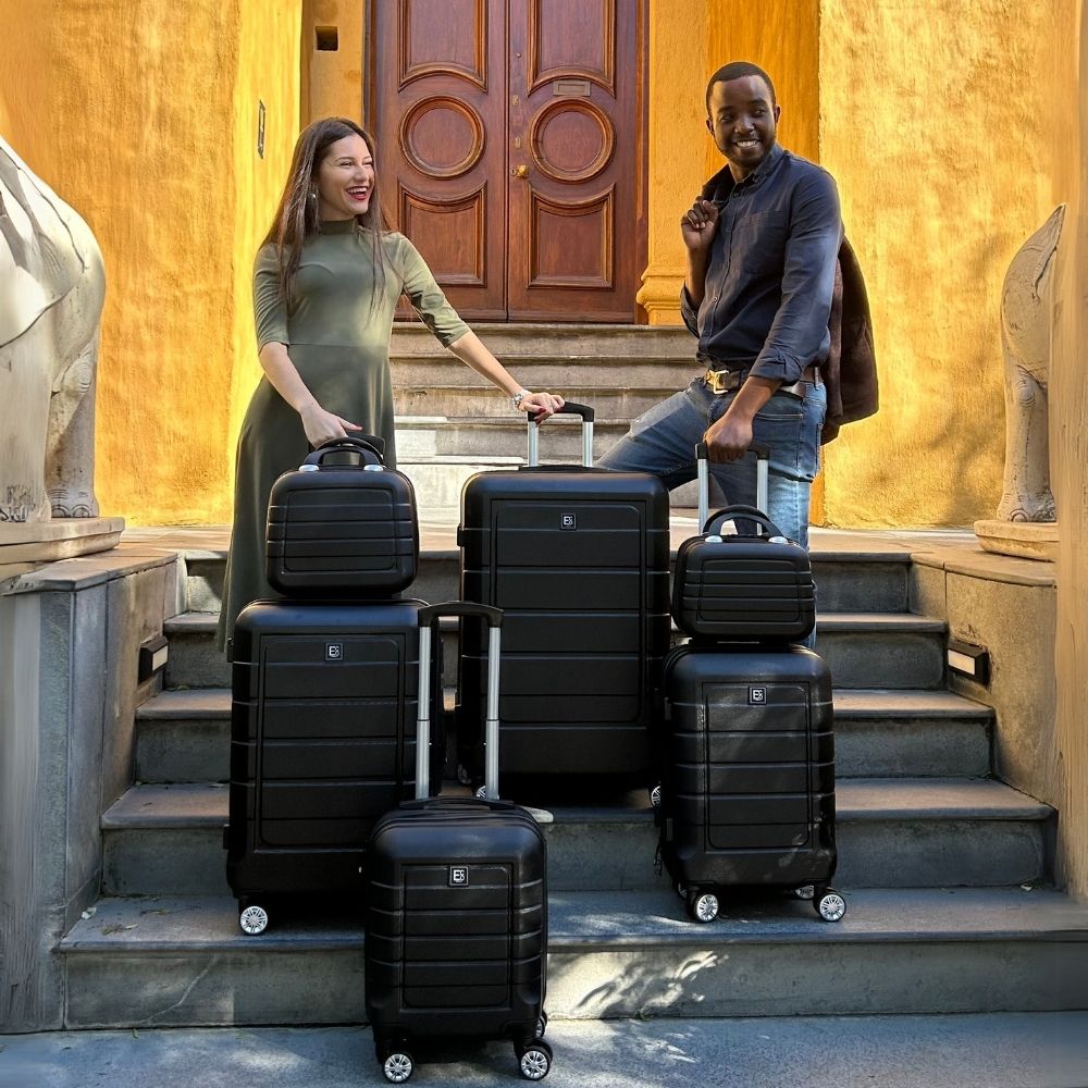 Lifestyle image of a couple with the Milan luggage set outside a hotel, highlighting its coordinated design, urban elegance, and readiness for stylish travel moments