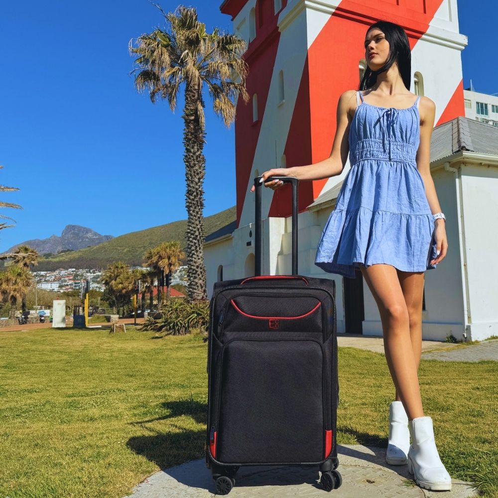 Lifestyle image of the Monaco luggage set in an outdoor setting, with a couple nearby, highlighting its coordinated design, sleek silhouette, and premium build suited for elevated travel experiences
