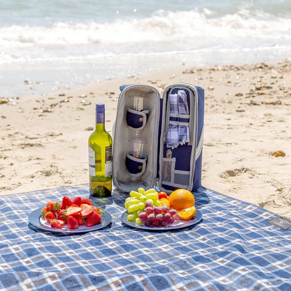 Lifestyle image of the insulated wine cooler bag placed on the beach with food items, highlighting its portability, stylish design, and suitability for outdoor gatherings