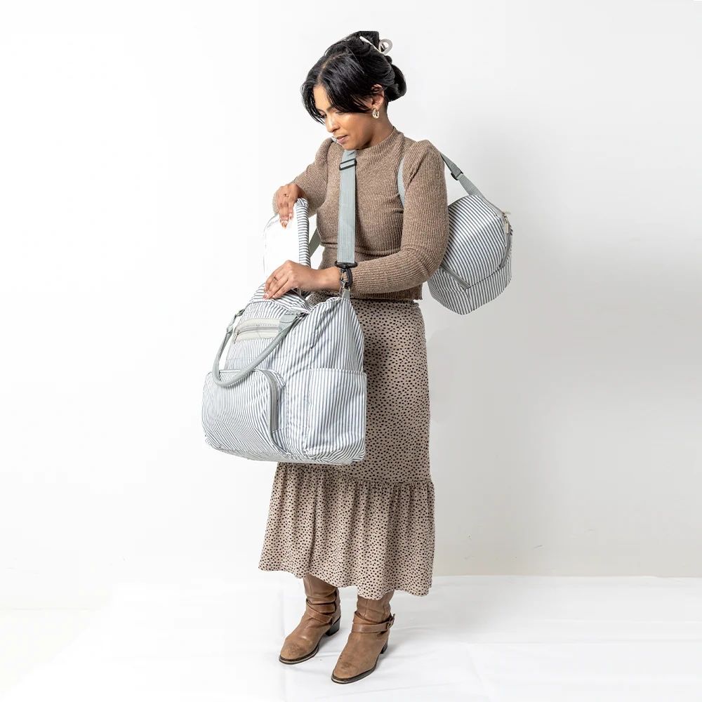 Woman carrying striped diaper bag set and unpacking essentials – lifestyle product image 01