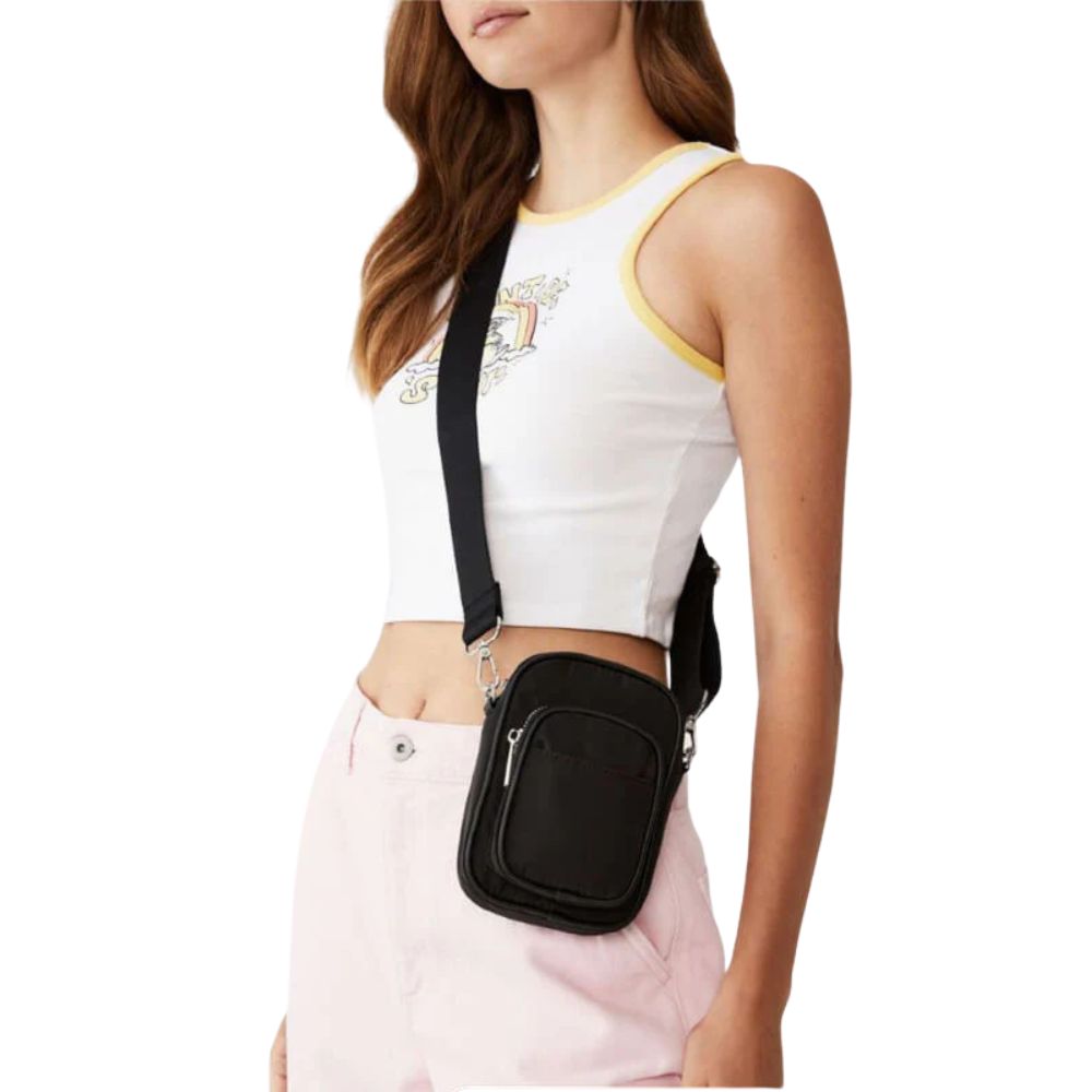 Lifestyle image of the Crossbody Shoulder Bag resting on a café table beside coffee and travel essentials, evoking a relaxed and stylish travel vibe