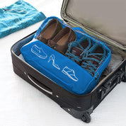 Lifestyle image of the Shoe Bag placed in a travel setting, with its compact form visible beside other accessories, highlighting its utility for organized packing and on-the-go convenience